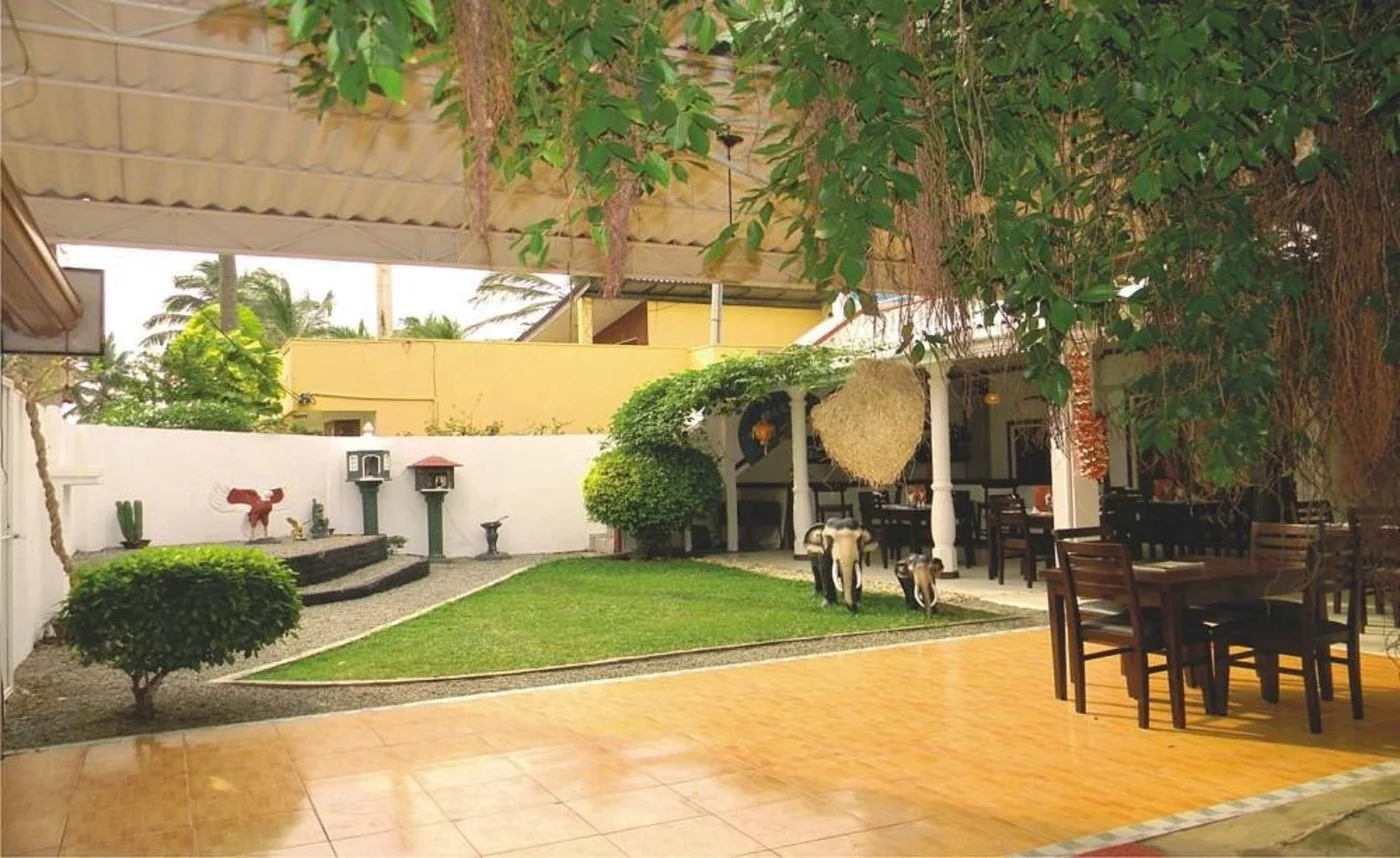 BAYWATCH courtyard with greenery, a lawn and outdoor tables