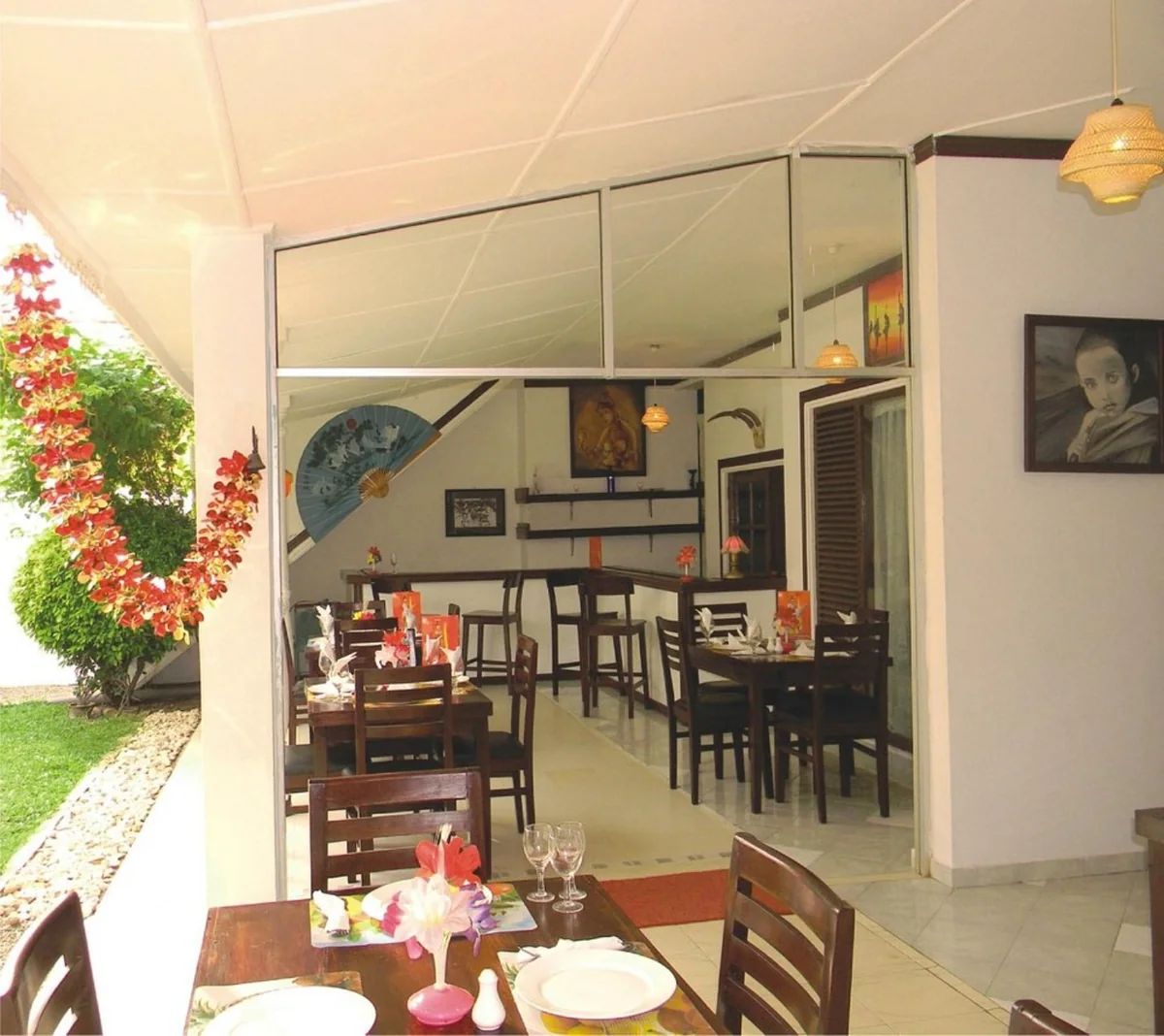 BAYWATCH dining area with wooden tables and chairs beside the courtyard