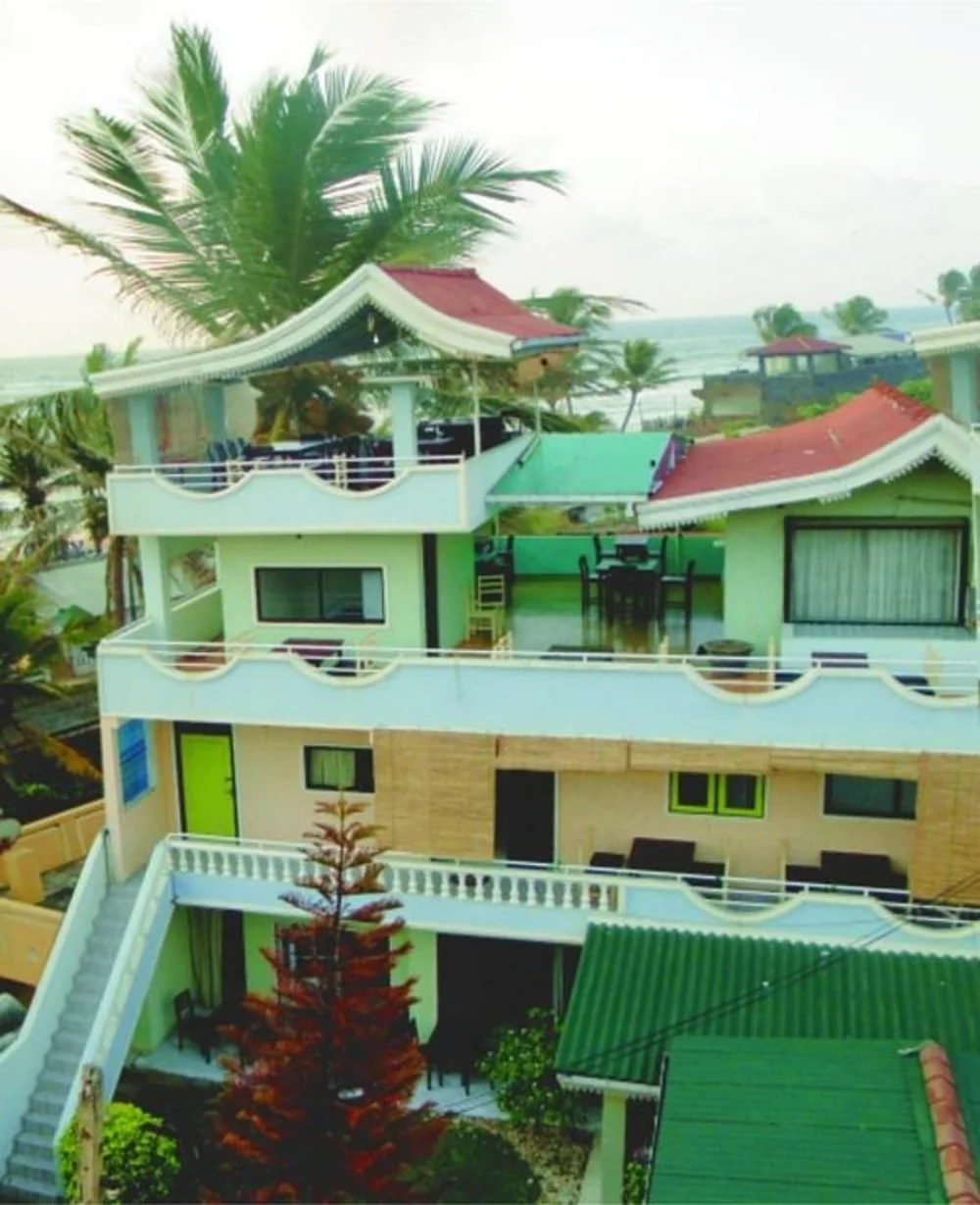 BAYWATCH hotel exterior with balconies, palm trees and the sea beyond